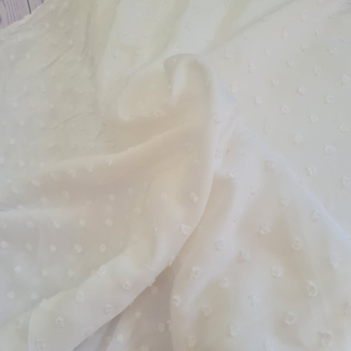 Viscose dobby textured spot polkadot dress fabric. Sage green and white