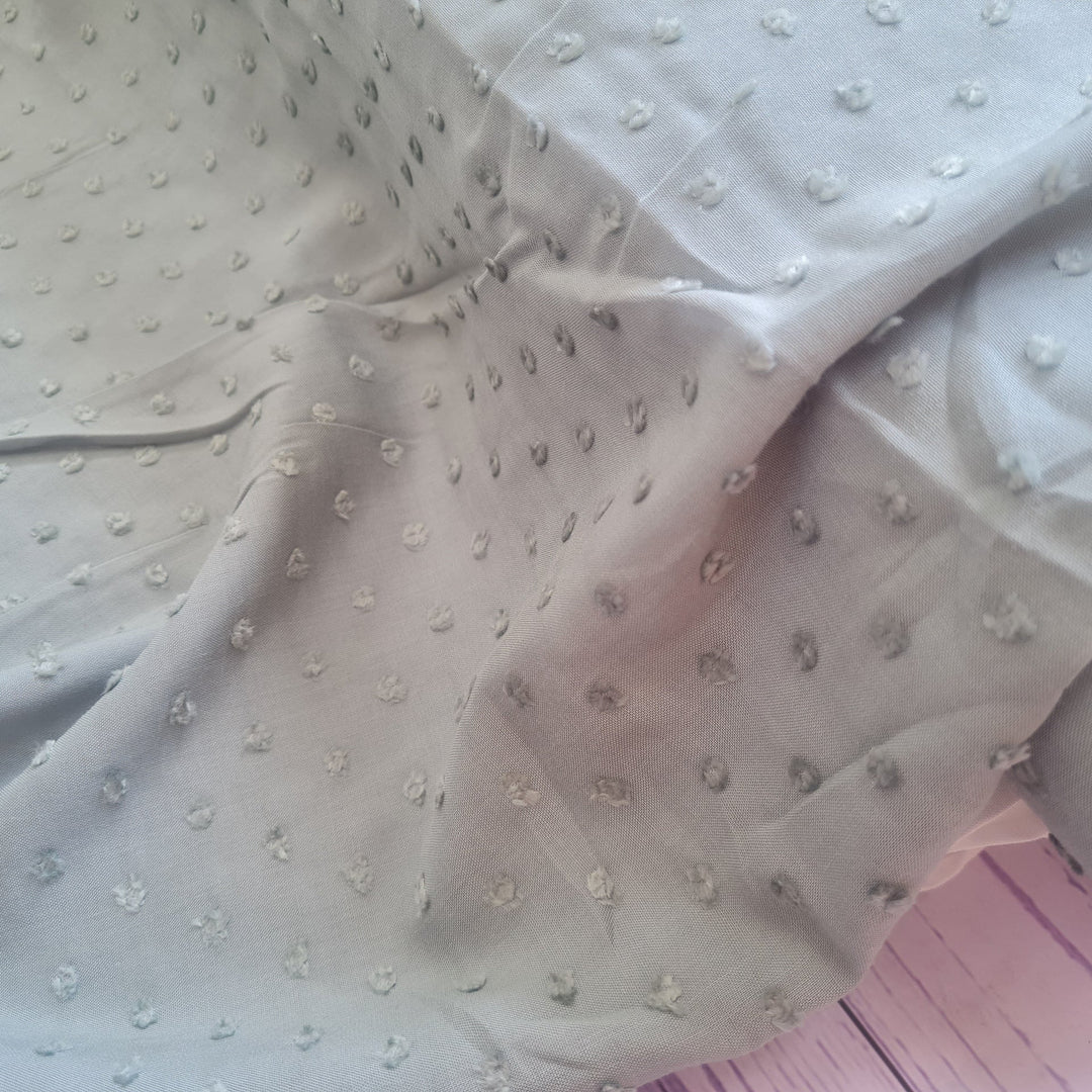 Viscose dobby textured spot polkadot dress fabric. Sage green and white