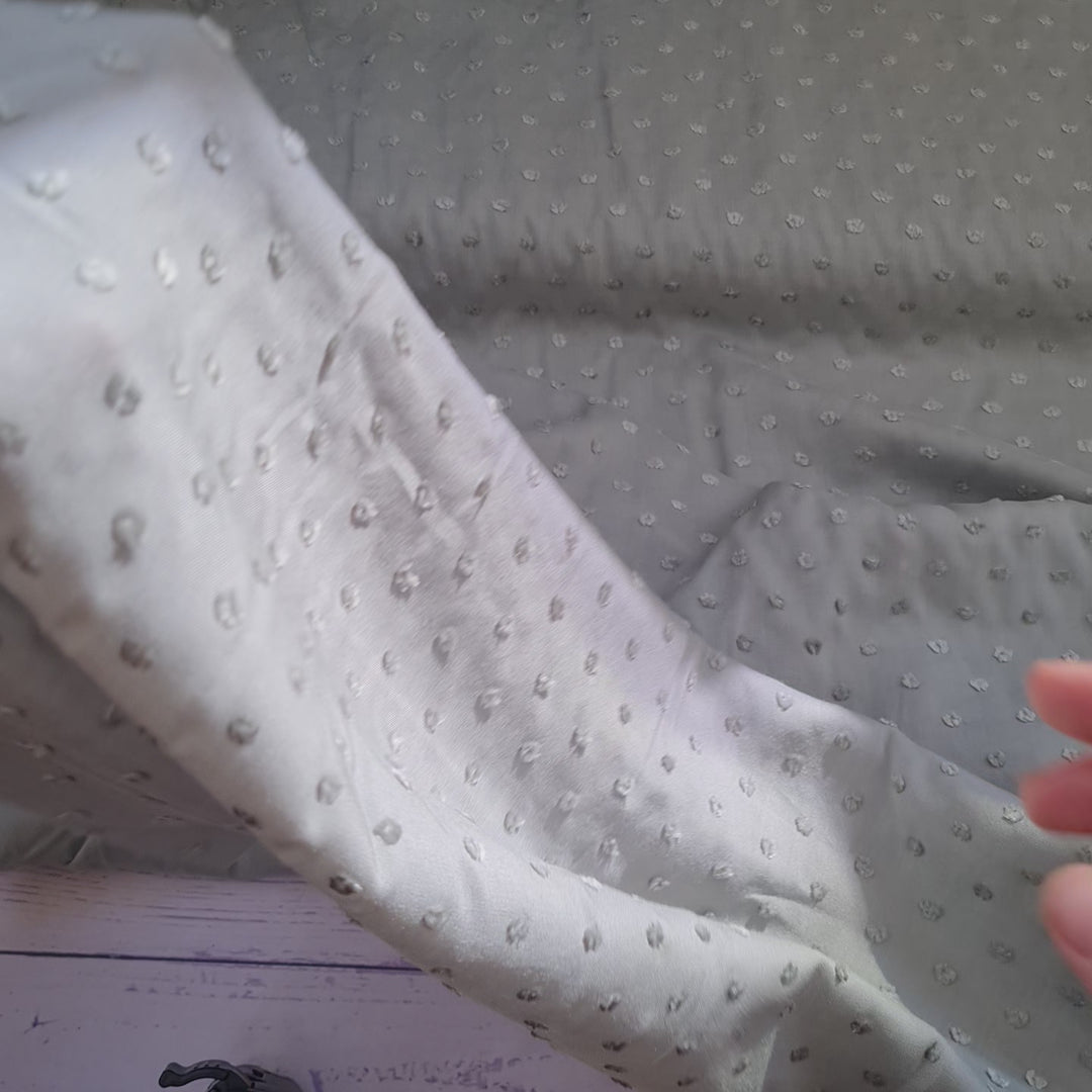 Viscose dobby textured spot polkadot dress fabric. Sage green and white